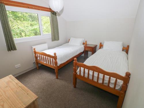 two twin beds in a room with a window at Cabin No 5 - Salt and Fern Cabins in Port Talbot