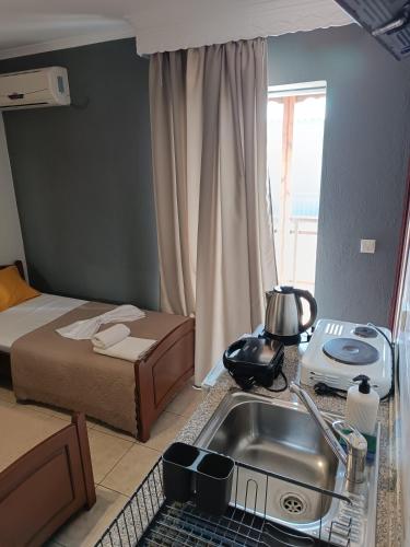 a small kitchen with a sink and a bed and a sink at Hotel Manos in Paralia Katerinis