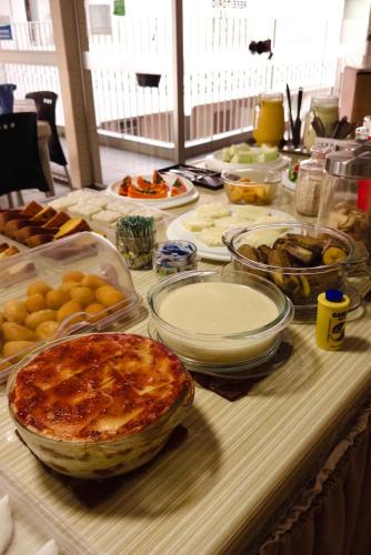 a table topped with lots of different types of food at Pousada São Luiz in Aracaju