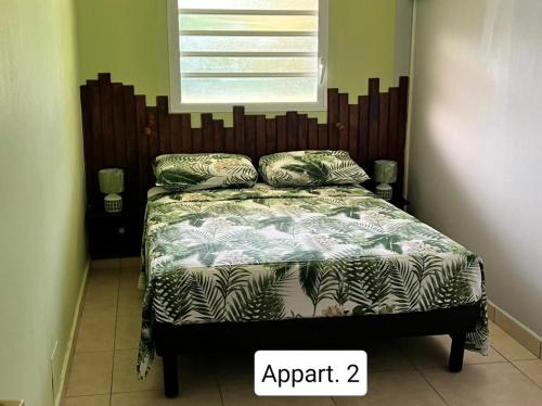 a bedroom with a bed with a large headboard at Ti Kaz en Nou' in Pointe-Noire