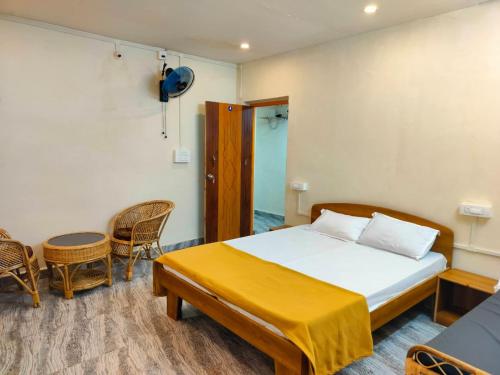 a bedroom with a bed and a table and chairs at Mangrove Village Inn in Kāsarkod