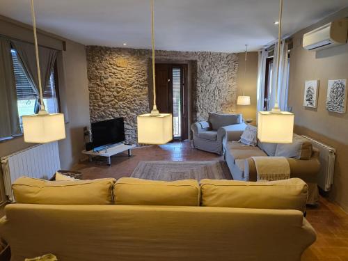 a living room with two couches and a tv at L'Era de Can Ribes Tor in Tor