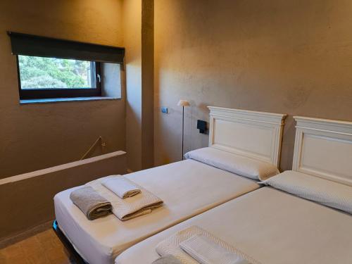 two beds in a room with towels on them at L'Era de Can Ribes Tor in Tor