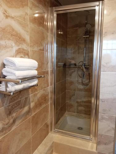 a shower with a glass door and some towels at Appartement Fort Lamalgue in Toulon