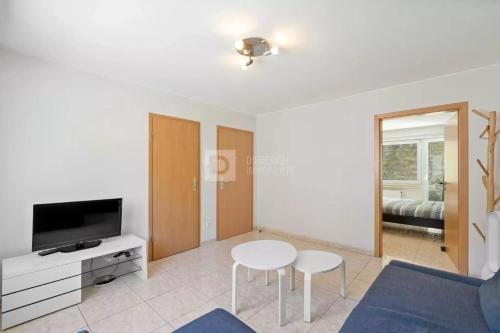 a living room with a table and a tv at Centerluxfirst in Luxembourg