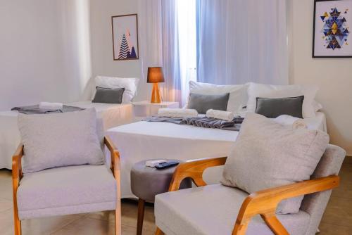 a living room with two beds and a chair at Diamond Hotéis e Flats in São Lourenço