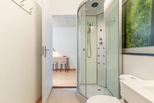 a bathroom with a glass shower and a toilet at Host In Olivença in Vila Nova de Famalicão