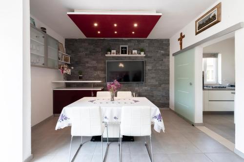 a kitchen with a white table with a vase of flowers on it at Villa Lucia in Mokošica