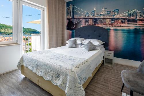 a bedroom with a bed and a large window at Villa Lucia in Mokošica