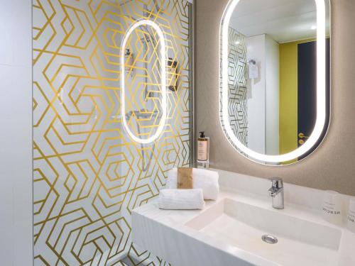 a bathroom with a sink and a mirror at Mercure Honfleur in Honfleur