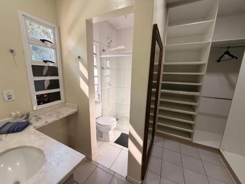 a bathroom with a sink and a toilet and a shower at Casa Nina, com Piscina e Brinquedoteca, Super Próxima das Cataratas e Aeroporto in Foz do Iguaçu