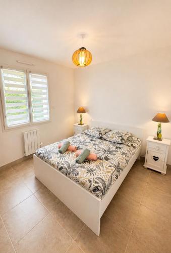 a bedroom with a bed and two night stands at Charmante maison neuve proche Ocean in Léon