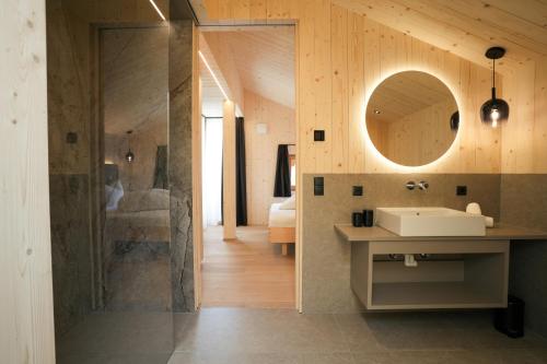 a bathroom with a shower and a sink and a mirror at Preindlerhof Farmloft in Valle Di Casies