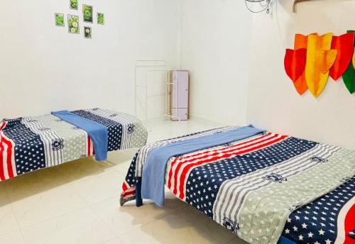 two beds in a room with american flag blankets at Châu Gia Vỹ Dạ Hàn Mạc Tử in Thôn Lại Thê