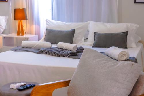 a white bed with pillows and a remote control on it at Diamond Hotéis e Flats in São Lourenço