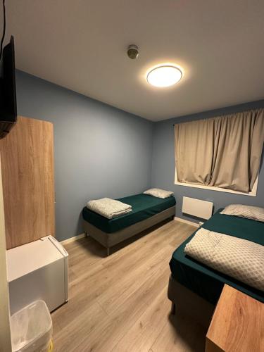 a room with two beds and a television in it at Ahmad sweet home in Vardø