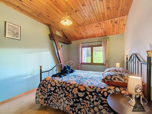 a bedroom with a bed and a wooden ceiling at Le Gite Cazette in Ance