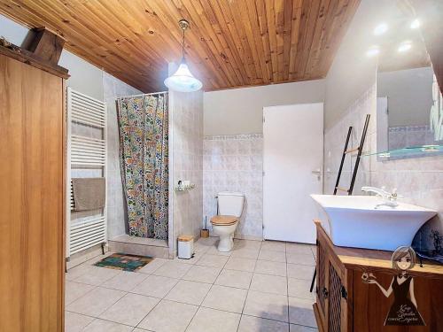a bathroom with a tub and a sink and a toilet at Le Gite Cazette in Ance