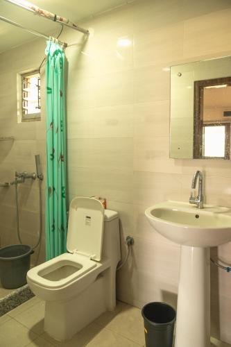 a bathroom with a toilet and a sink at Raj Garden Resort in Guwahati