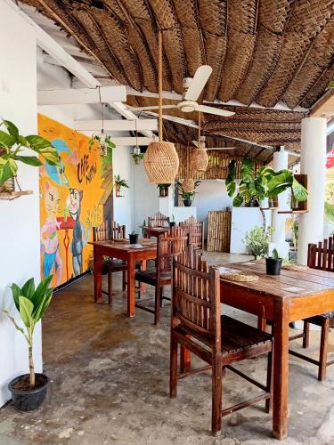 a restaurant with wooden tables and chairs and a mural at Wave Hunters Arugam Bay in Arugam Bay