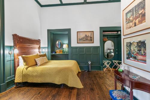 a bedroom with green walls and a bed with a yellow bedspread at Spacious Studio on Historic Inn Property in Asheville