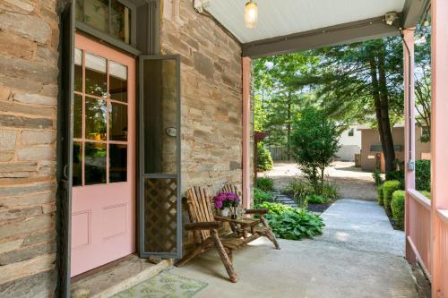 a porch with a pink door and a bench at Spacious Studio on Historic Inn Property in Asheville