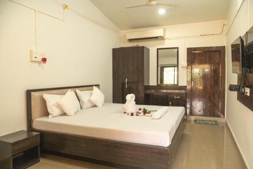 a bedroom with a bed with a teddy bear sitting on it at Raj Garden Resort in Guwahati