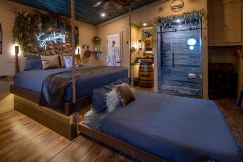 a bedroom with two beds and a walk in shower at "Tree-T-Ment Center" Spa-Themed Luxury Treehouse with Indoor & Outdoor Soaking Tubs in Sevierville