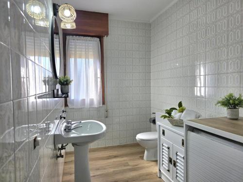 a white bathroom with a sink and a toilet at Apartamento La Hojarada 20809 in Argoños