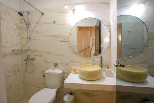 a bathroom with a toilet and a sink and a mirror at Corfu Spanos House in Sokraki in Sokrákion
