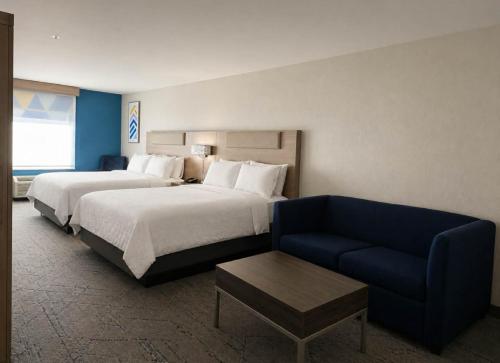 a hotel room with two beds and a couch at Holiday Inn Express & Suites Murphy by IHG in Murphy