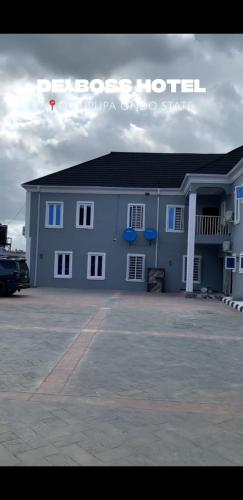 a blue building with two blue chairs in a parking lot at DE'BOSS hotels and suites in Okitipupa