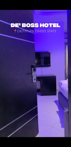 a room with a bed and a purple wall at DE'BOSS hotels and suites in Okitipupa