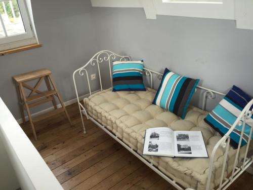 a white couch with pillows and a book on it at Le Loft du Clocheton in Étretat