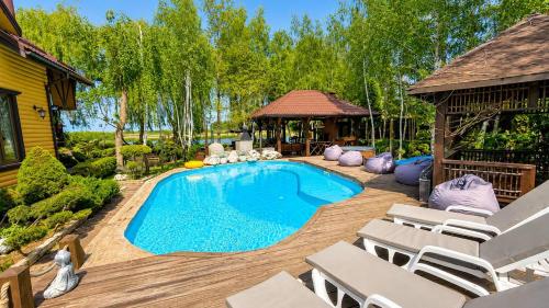 a swimming pool in a yard with chairs and a gazebo at Дом на берегу 1dom club in Protsev