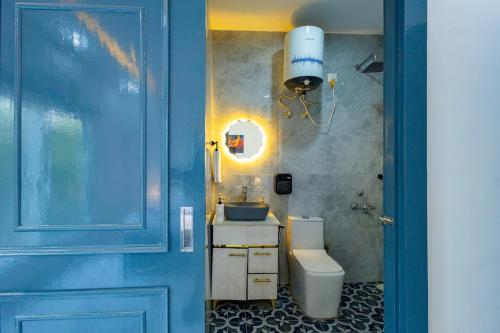 a bathroom with a toilet and a sink and a blue door at Luxury Haven Stay in Noida
