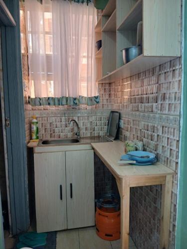 a small kitchen with a sink and a window at Amazing Grace Home - Oyugis studio in Oyugis
