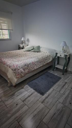 a bedroom with a bed and a wooden floor at La Candela in Olavarría