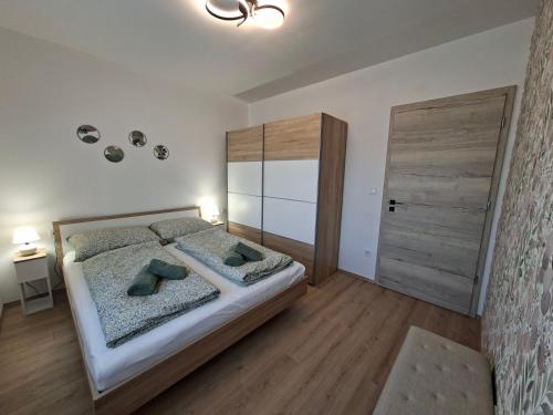 a bedroom with a large bed and a wooden door at Green Nest Apartment in Sárvár