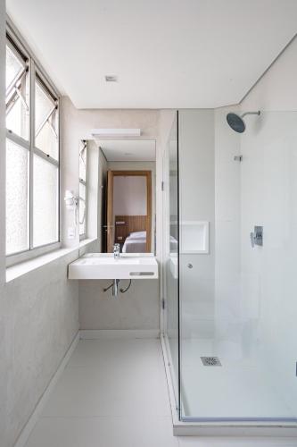 a white bathroom with a sink and a shower at Moov Hotel São Paulo in São Paulo