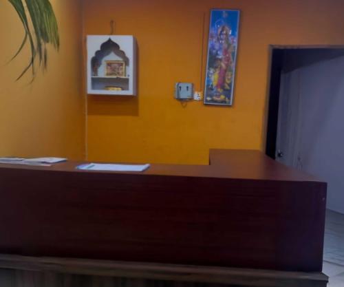 a reception desk in a room with a yellow wall at Hotel O Kalinga Regency in Khandagiri