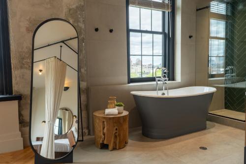 a bathroom with a large tub and a mirror at Sela V Hotel in Brooklyn