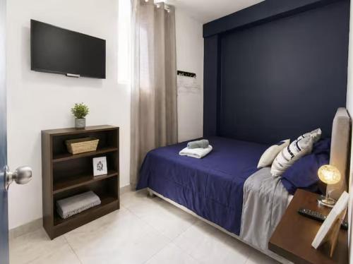 a bedroom with a bed and a tv on the wall at Sunset In Malabrigo in Puerto Chicama
