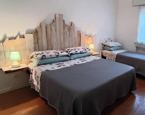 a bedroom with a large bed with a wooden headboard at Casa Vintago b&b in Savio di Ravenna