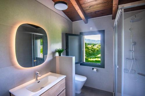 a bathroom with a sink and a toilet and a mirror at Casas Green Ordesa in Aínsa