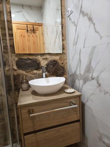 a bathroom with a white sink and a shower at O Muiño do Torneiro in A Pobra do Caramiñal