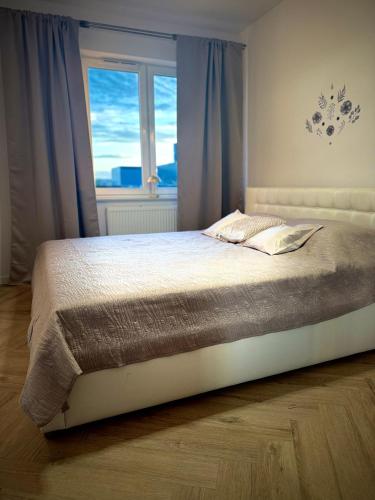 a bedroom with a large bed with a window at Kaszmirowy Apartament in Mrągowo