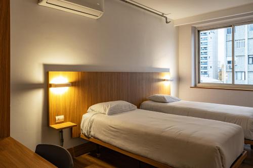 a room with two beds and a window at Moov Hotel São Paulo in São Paulo