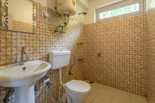 a bathroom with a toilet and a sink at La Heim Hostels in Manāli