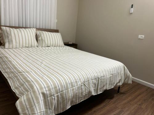 a bed with a striped comforter in a bedroom at Quiet Corner in Mafshatah